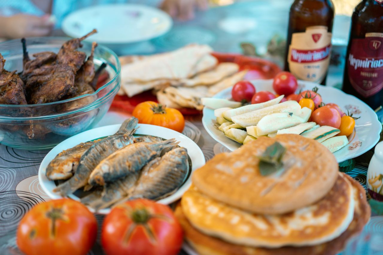 Services An enticing spread of grilled meats, fish, vegetables, and beer for a delicious outdoor picnic.