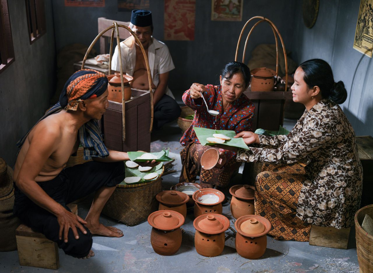 Family preparing traditional food in a Jakarta kitchen, showcasing cultural heritage.